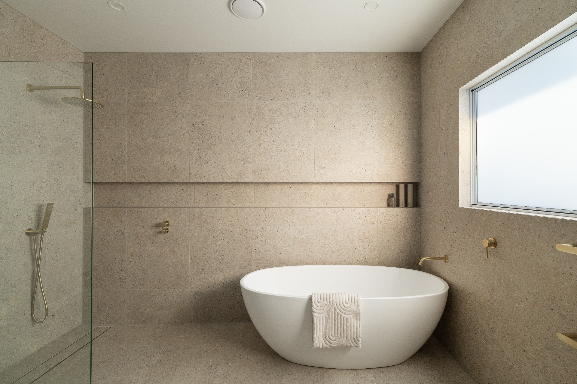 Stone-tiled bathroom with freestanding bath, Geebung