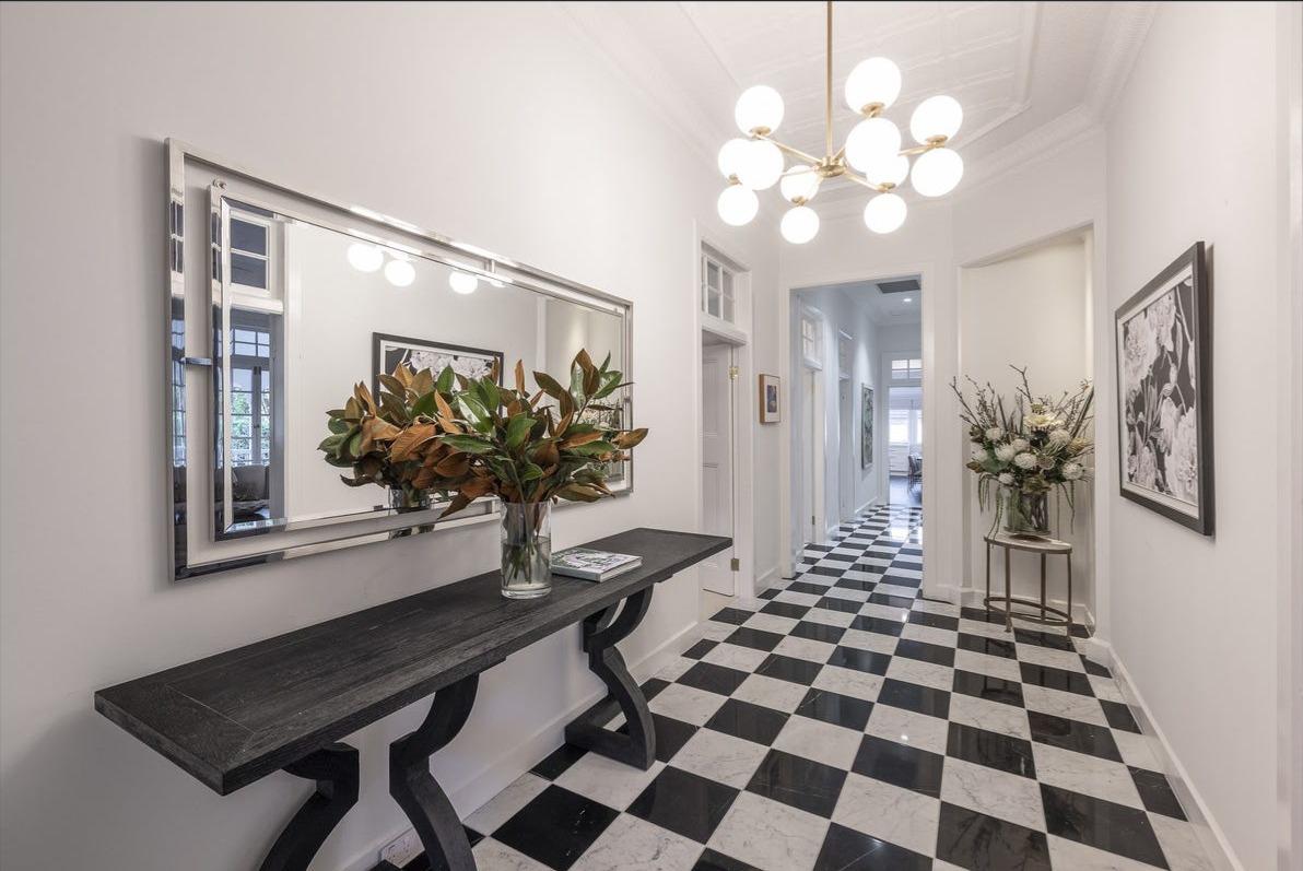 Grand entry hall with chequerboard marble floor and brass chandelier