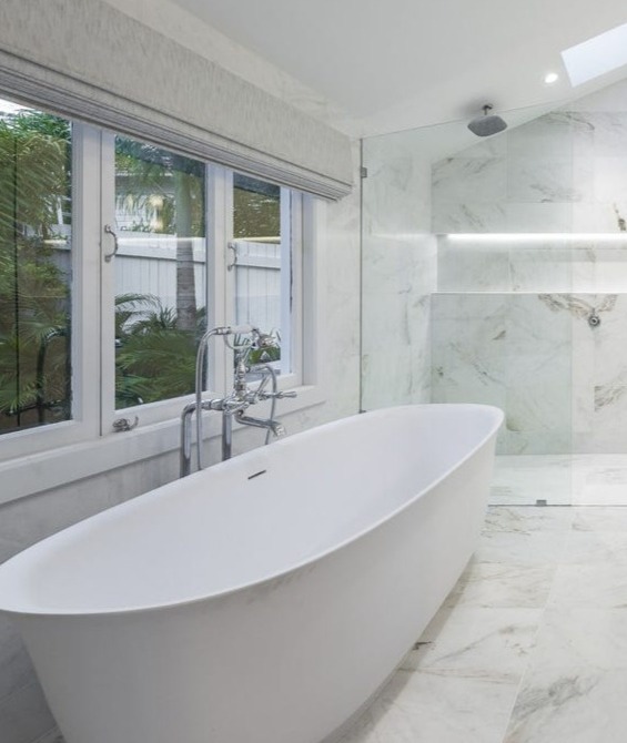 Marble bathroom with freestanding bath and garden outlook