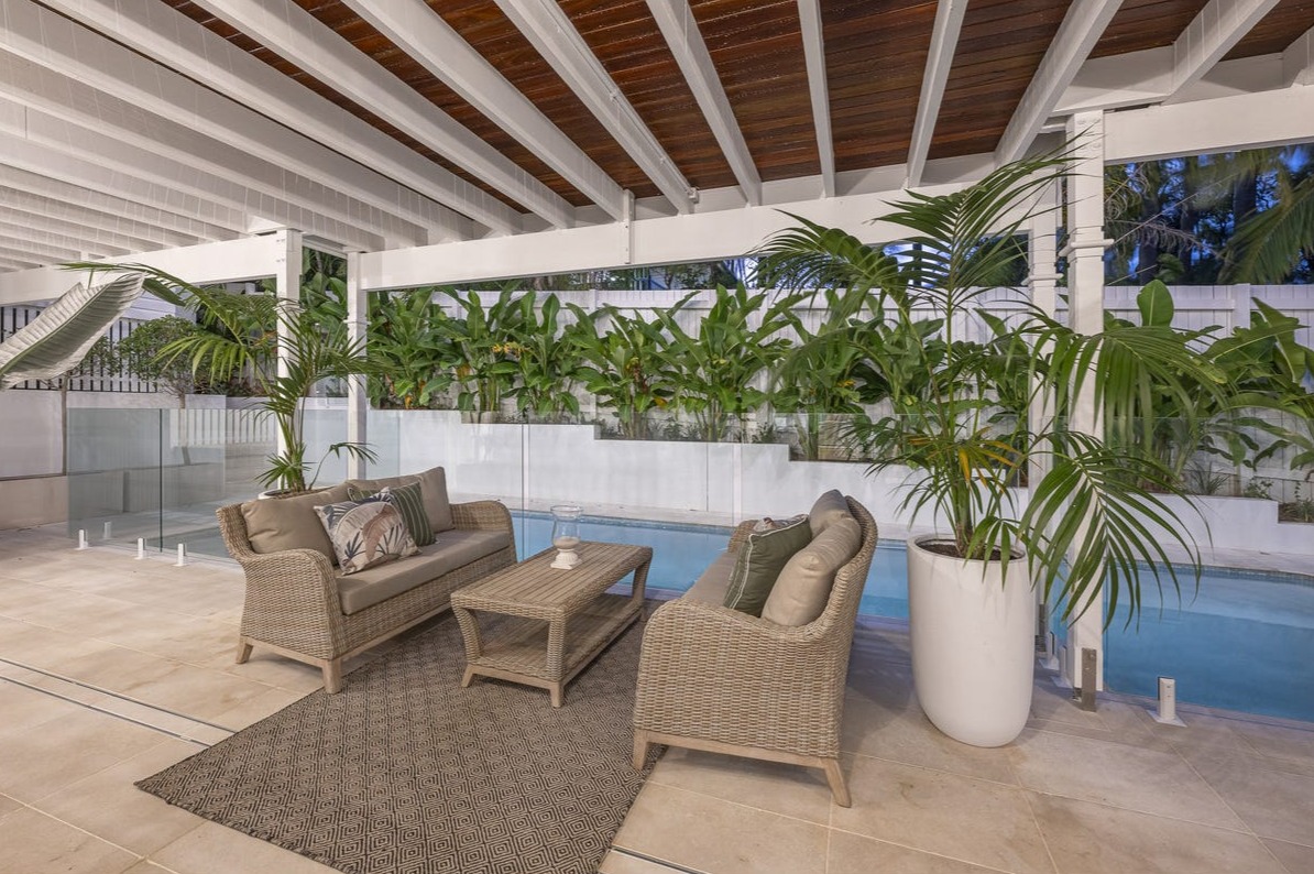 Poolside cabana with exposed timber ceiling and tropical planting